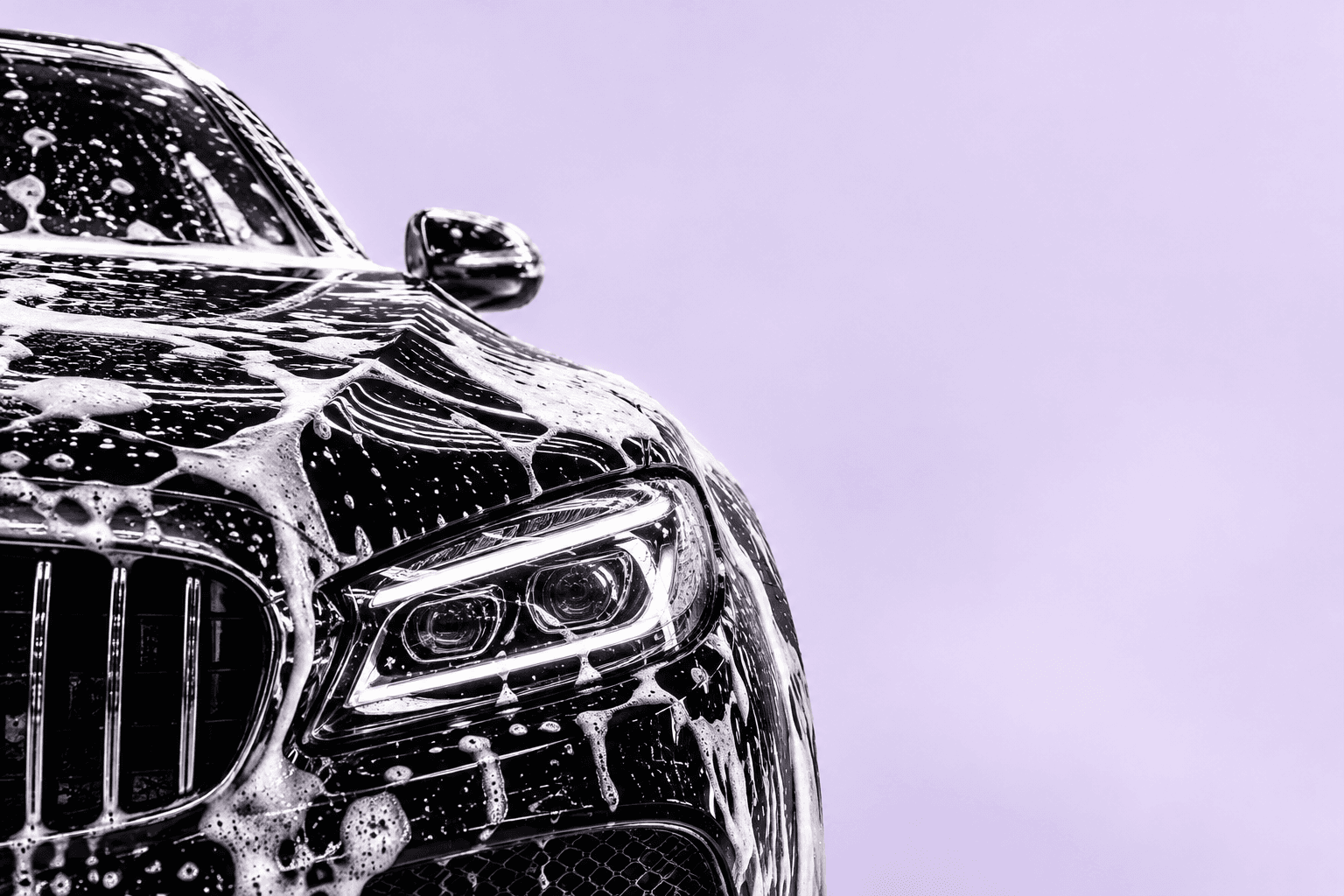 Car front covered in wash foam